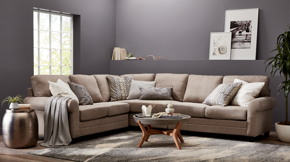 Living room with couch, window, hanging art and small coffee table.